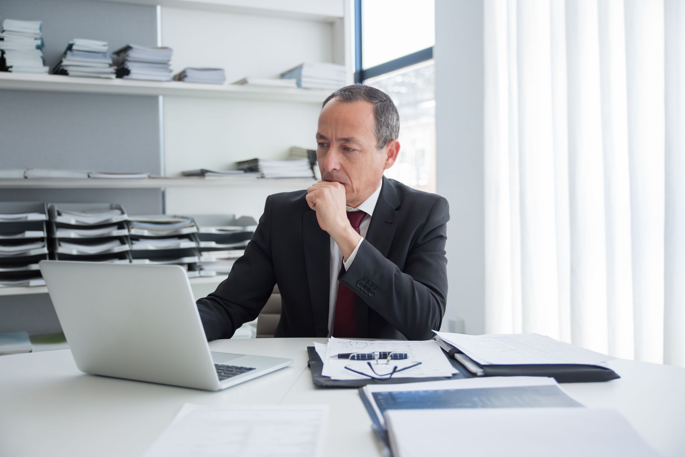 Business owner thinking through a problem at his desk